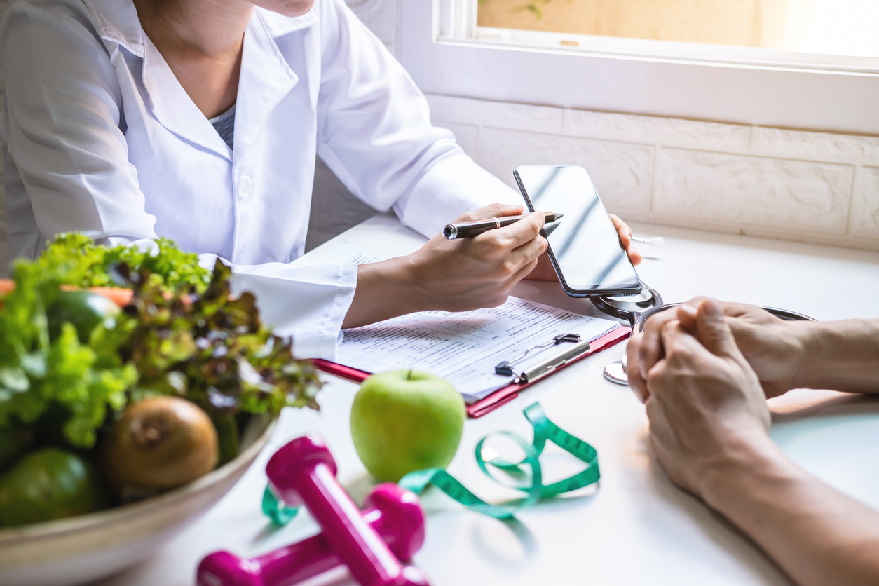 Nutritionist giving consultation to patient with healthy fruit and vegetable,