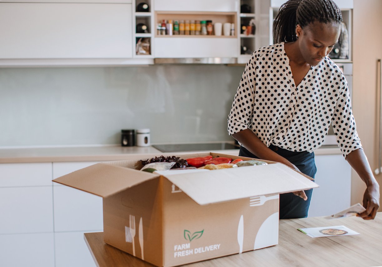 African Woman Opening Parcel With Meal Kit