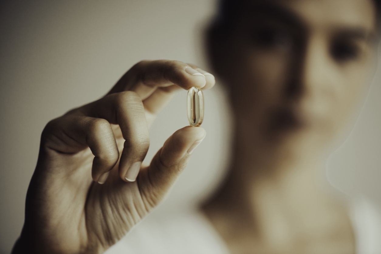 Woman Showing A Vitamin Capsule