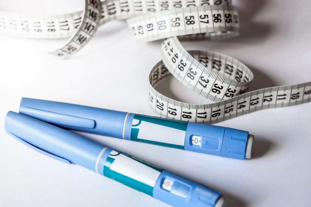 Ozempic injection pens next to a tape measurer