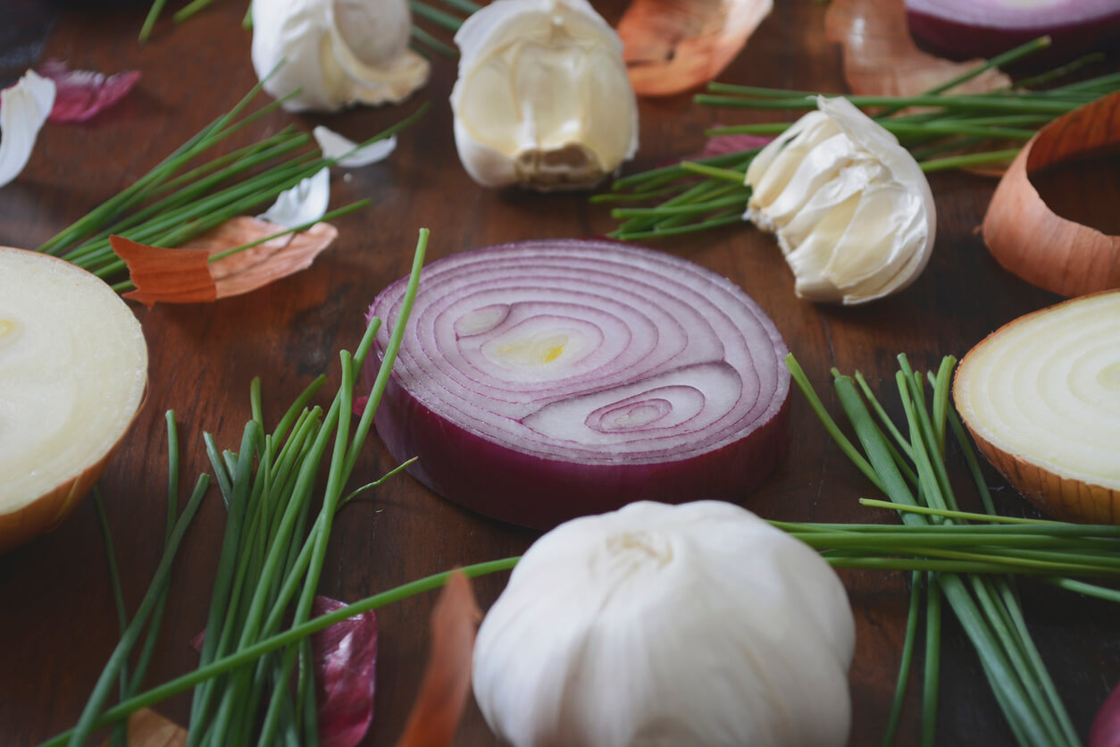 onion chives and garlic scattered on wood table