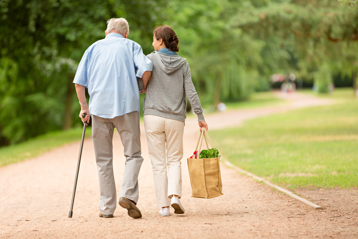 Caregiver woman helping senior man with shopping