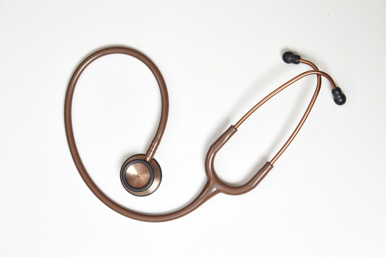 Red stethoscope medical equipment on white background