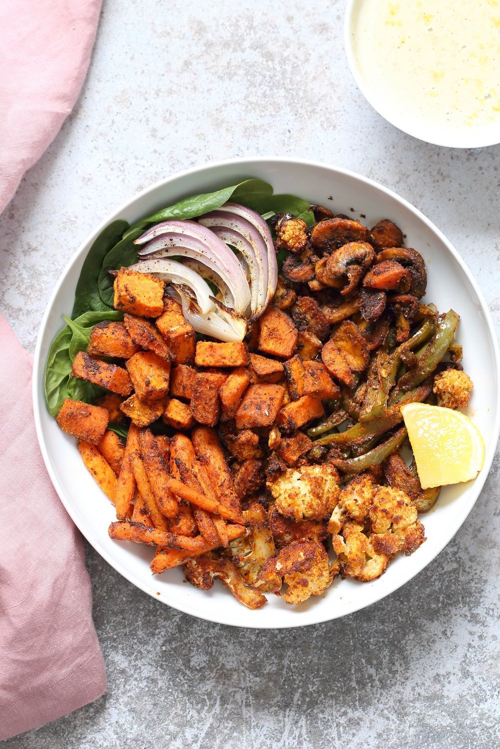 Vegan Cajun spiced roasted vegetable bowl with garlic sauce